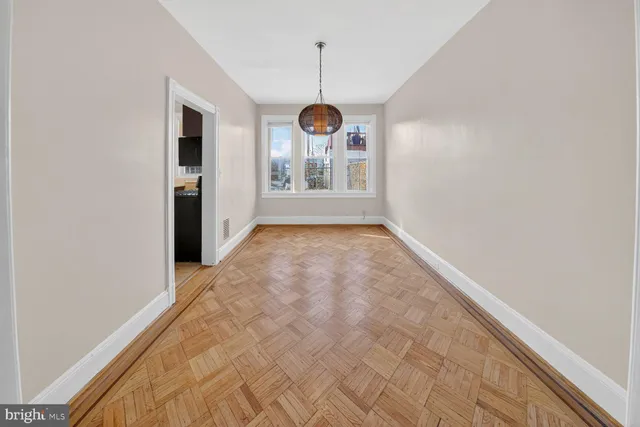a view of a hallway with wooden floor and a window
