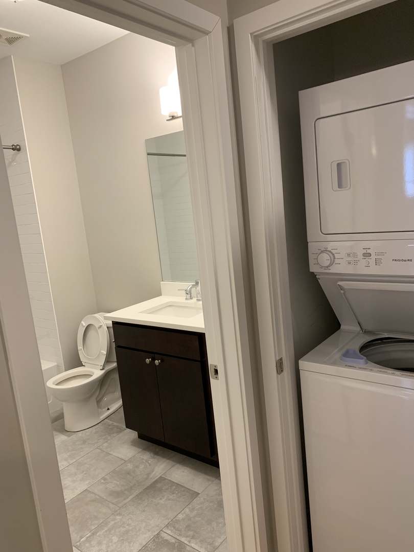 6125 North Clark Street, Unit 104 Chicago, IL 60660 - Photo 13 of 25 a bathroom with a sink a toilet and a mirror