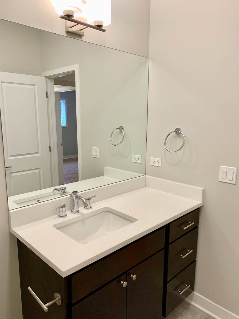6125 North Clark Street, Unit 104 Chicago, IL 60660 - Photo 14 of 25 a bathroom with a sink vanity and a mirror