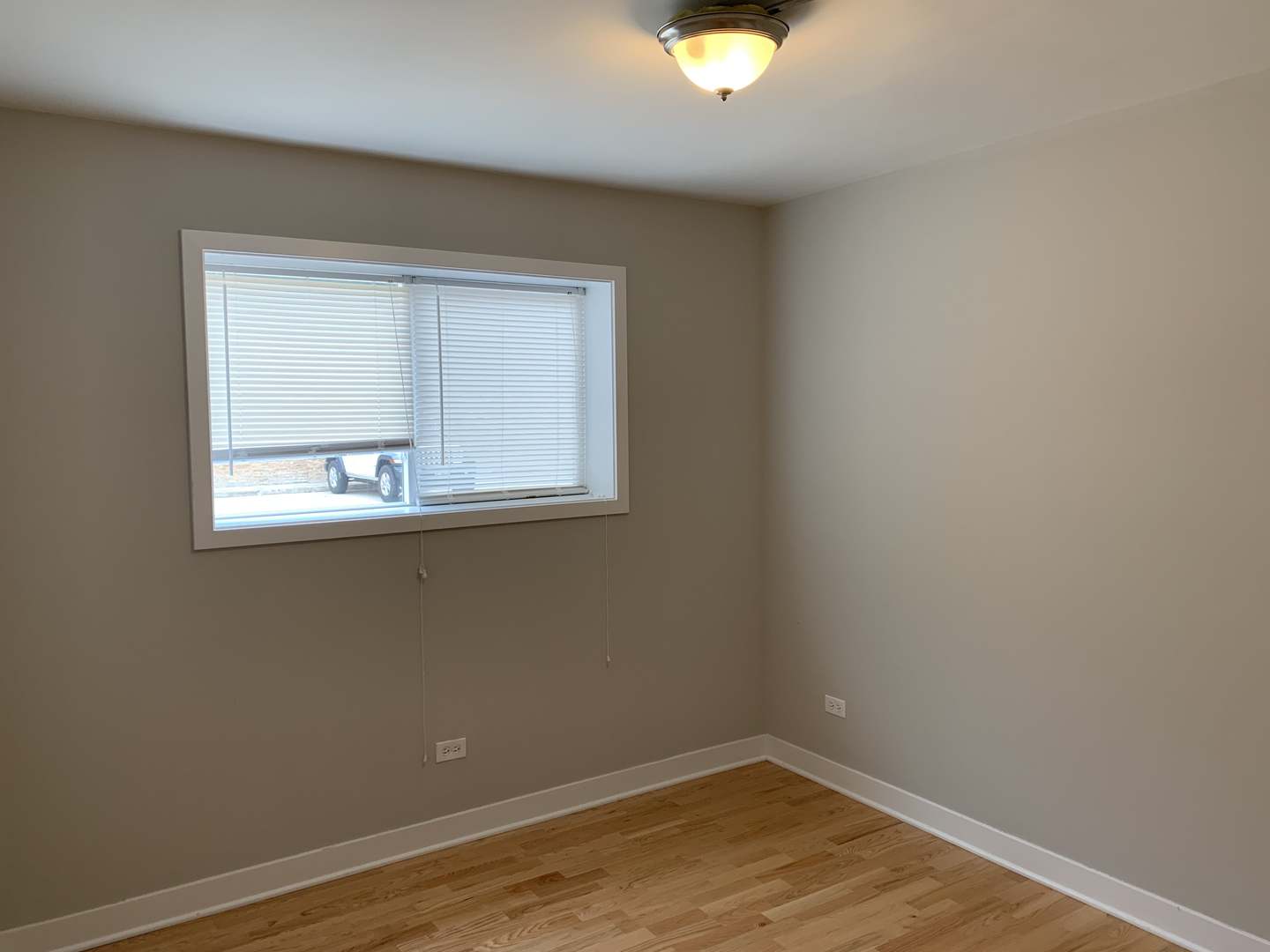6125 North Clark Street, Unit 104 Chicago, IL 60660 - Photo 19 of 25 an empty room with wooden floor and windows