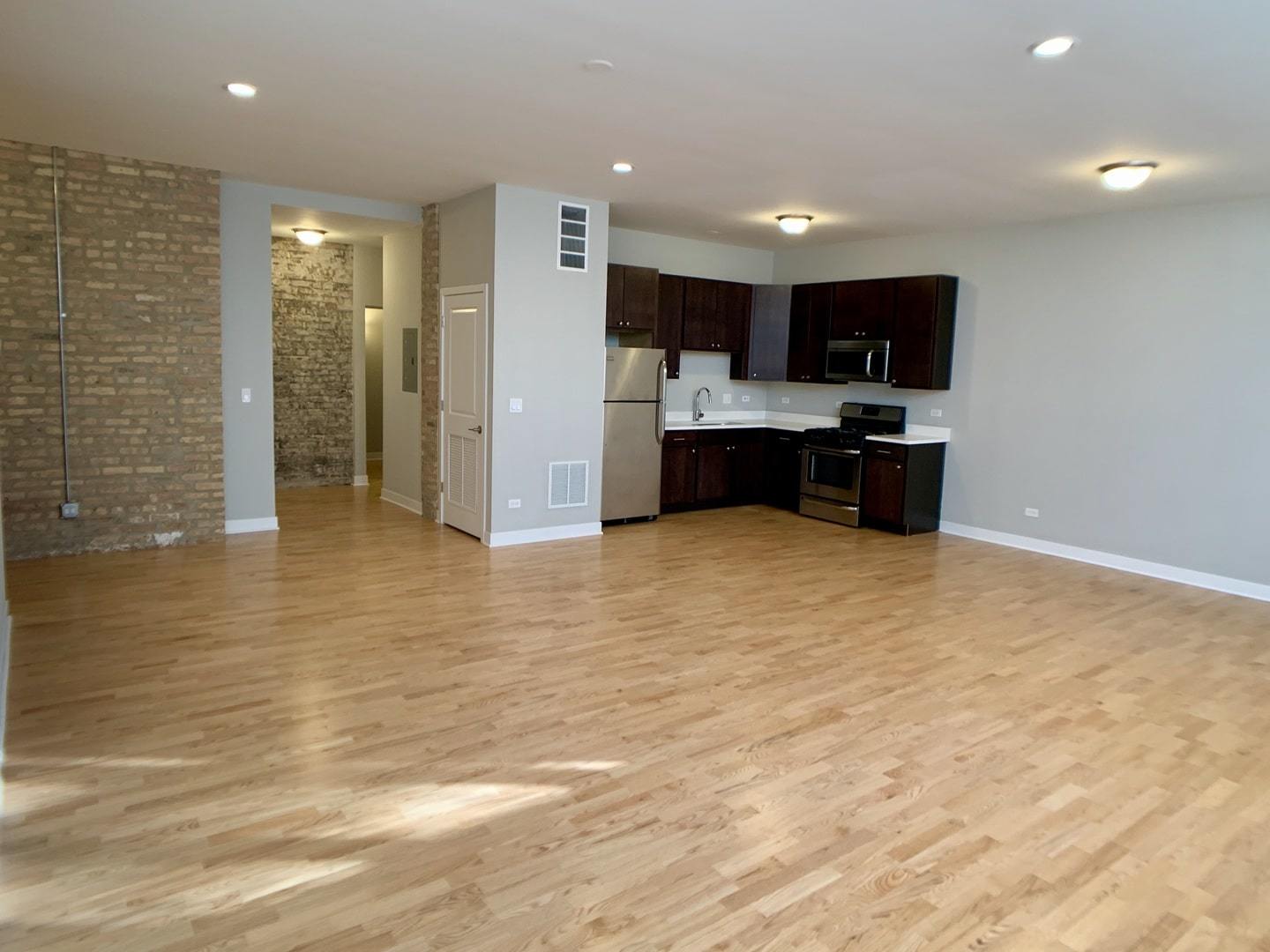 6125 North Clark Street, Unit 104 Chicago, IL 60660 - Photo 7 of 25 a large kitchen with stainless steel appliances a large counter top a stove and a refrigerator