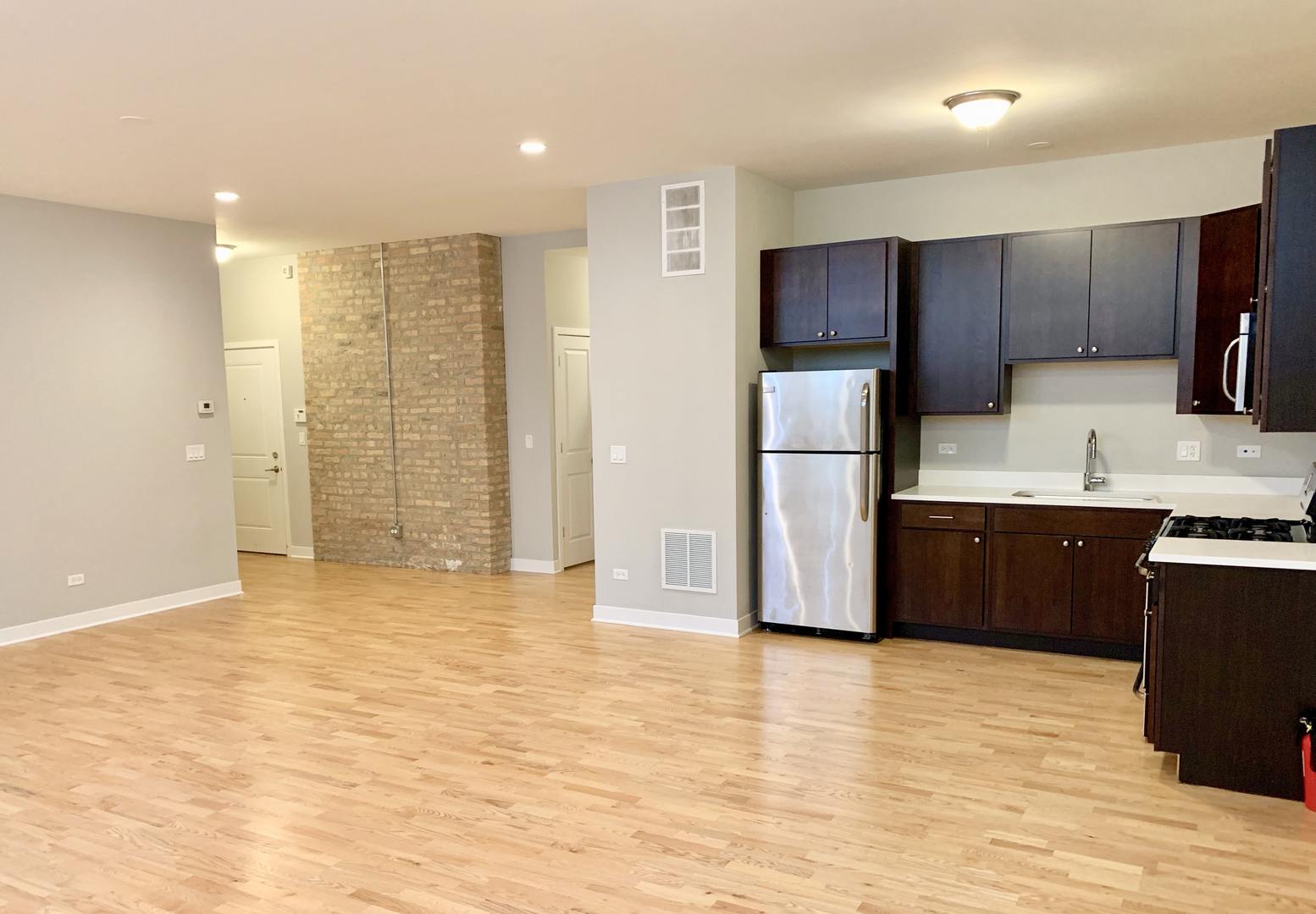 6125 North Clark Street, Unit 104 Chicago, IL 60660 - Photo 8 of 25 a kitchen with stainless steel appliances a refrigerator and a stove top oven