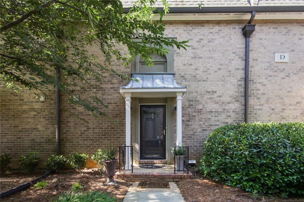 6980 Roswell Road, Unit D4 Atlanta, GA 30328 - Photo 1 of 1 a front view of a house with a tree