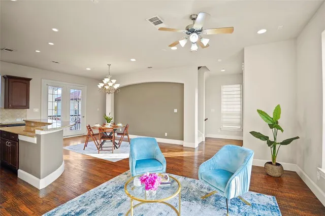a living room with furniture kitchen view and a chandelier