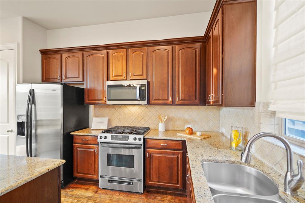 6748 Plaza Via Irving, TX 75039 - Photo 9 of 31 a kitchen with stainless steel appliances granite countertop a refrigerator stove and sink