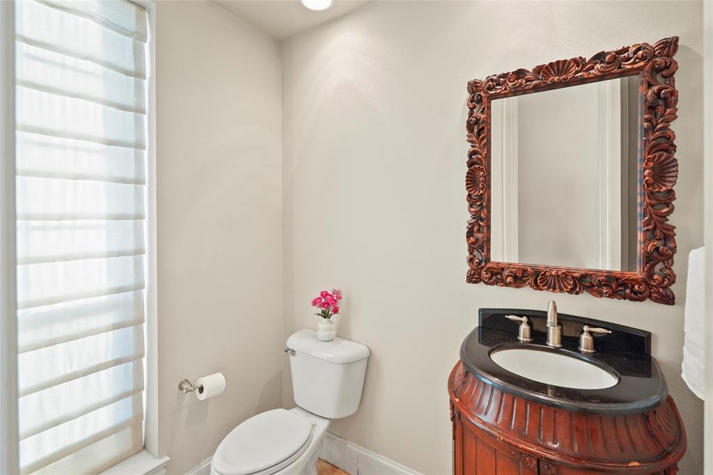 6748 Plaza Via Irving, TX 75039 - Photo 10 of 31 a bathroom with a toilet a sink and a mirror