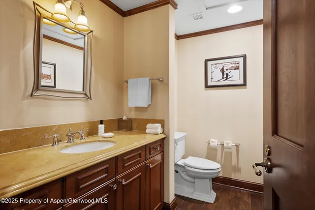 a bathroom with a granite countertop toilet sink and mirror