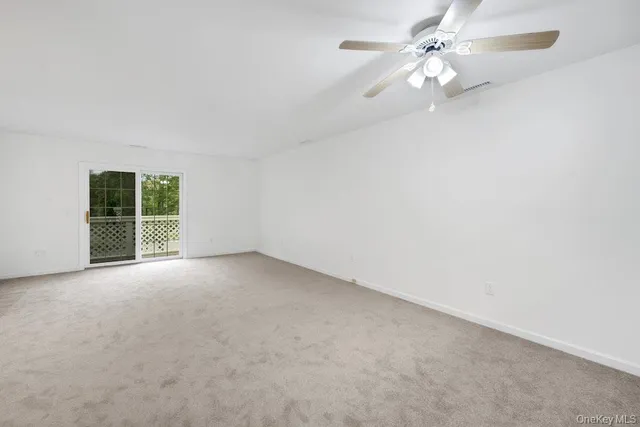 an empty room with a window and a ceiling fan