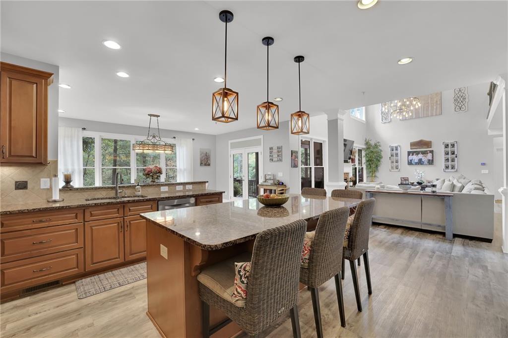 6010 Anchorage Quay Cumming, GA 30041 - Photo 23 of 72 a kitchen with stainless steel appliances granite countertop a kitchen island a stove and a wooden floors
