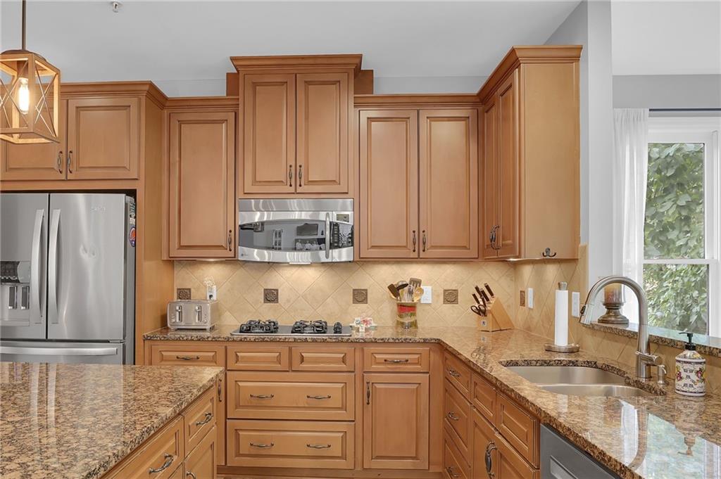 6010 Anchorage Quay Cumming, GA 30041 - Photo 26 of 72 a kitchen with stainless steel appliances granite countertop a sink stove and refrigerator