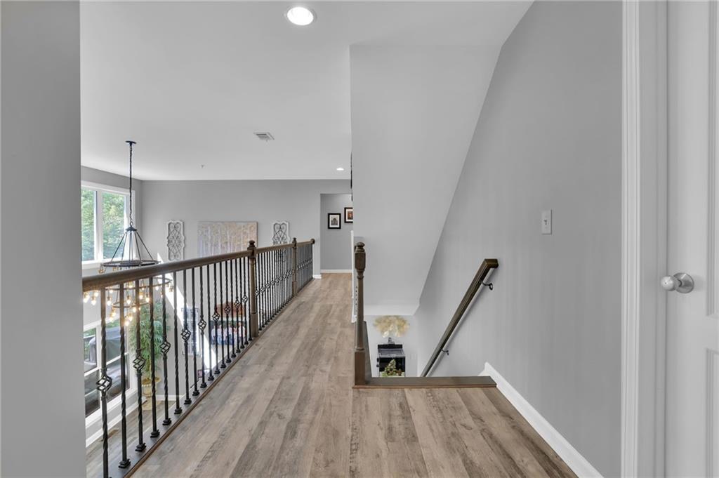 6010 Anchorage Quay Cumming, GA 30041 - Photo 33 of 72 a view of a hallway with wooden floor and staircase