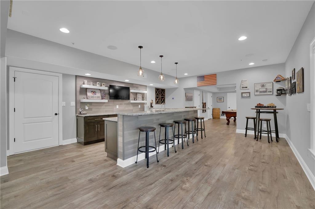 6010 Anchorage Quay Cumming, GA 30041 - Photo 55 of 72 a open kitchen with stainless steel appliances granite countertop a stove top oven a sink dishwasher and a dining table with wooden floor