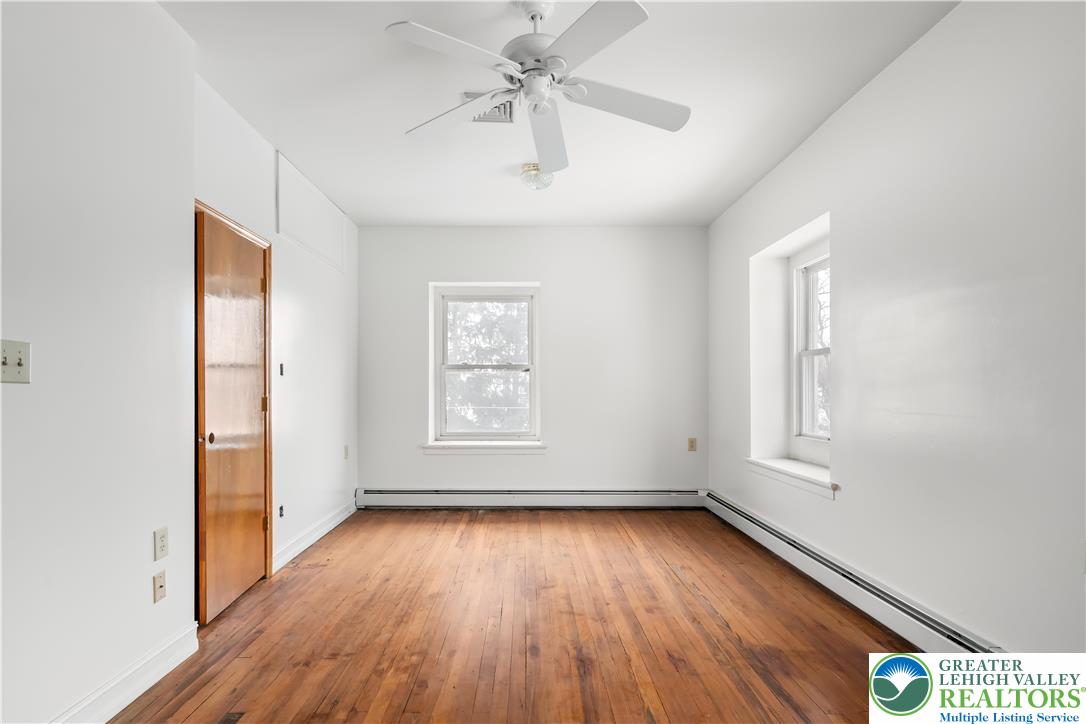 384 Evansville Road Fleetwood, PA 19522 - Photo 23 of 54 an empty room with wooden floor chandelier fan and windows