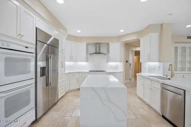 a kitchen with stainless steel appliances granite countertop a refrigerator and a stove