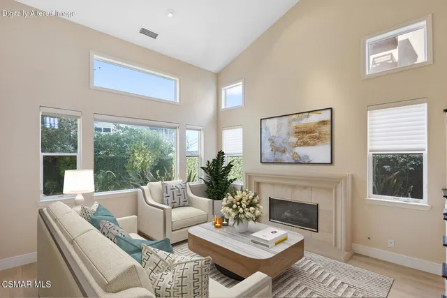 a living room with furniture a fireplace and a large window