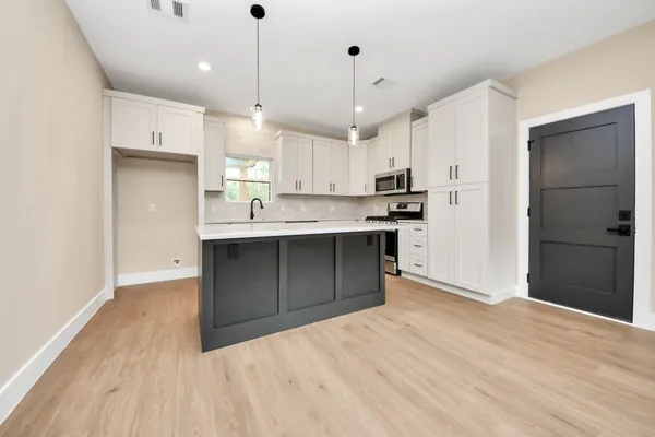 a kitchen with kitchen island a sink stainless steel appliances and cabinets