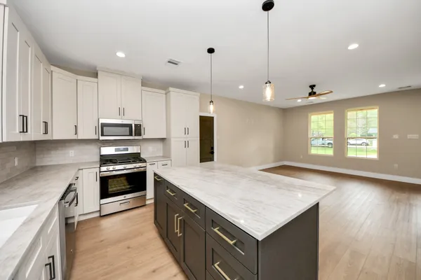 a kitchen with stainless steel appliances granite countertop a refrigerator a sink and a stove