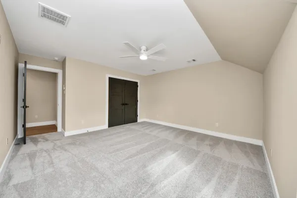 a view of an empty room with a ceiling fan