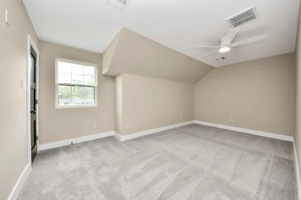 an empty room with a window and a ceiling fan