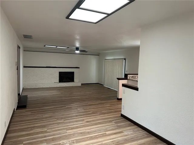 a view of empty room with wooden floor and fireplace