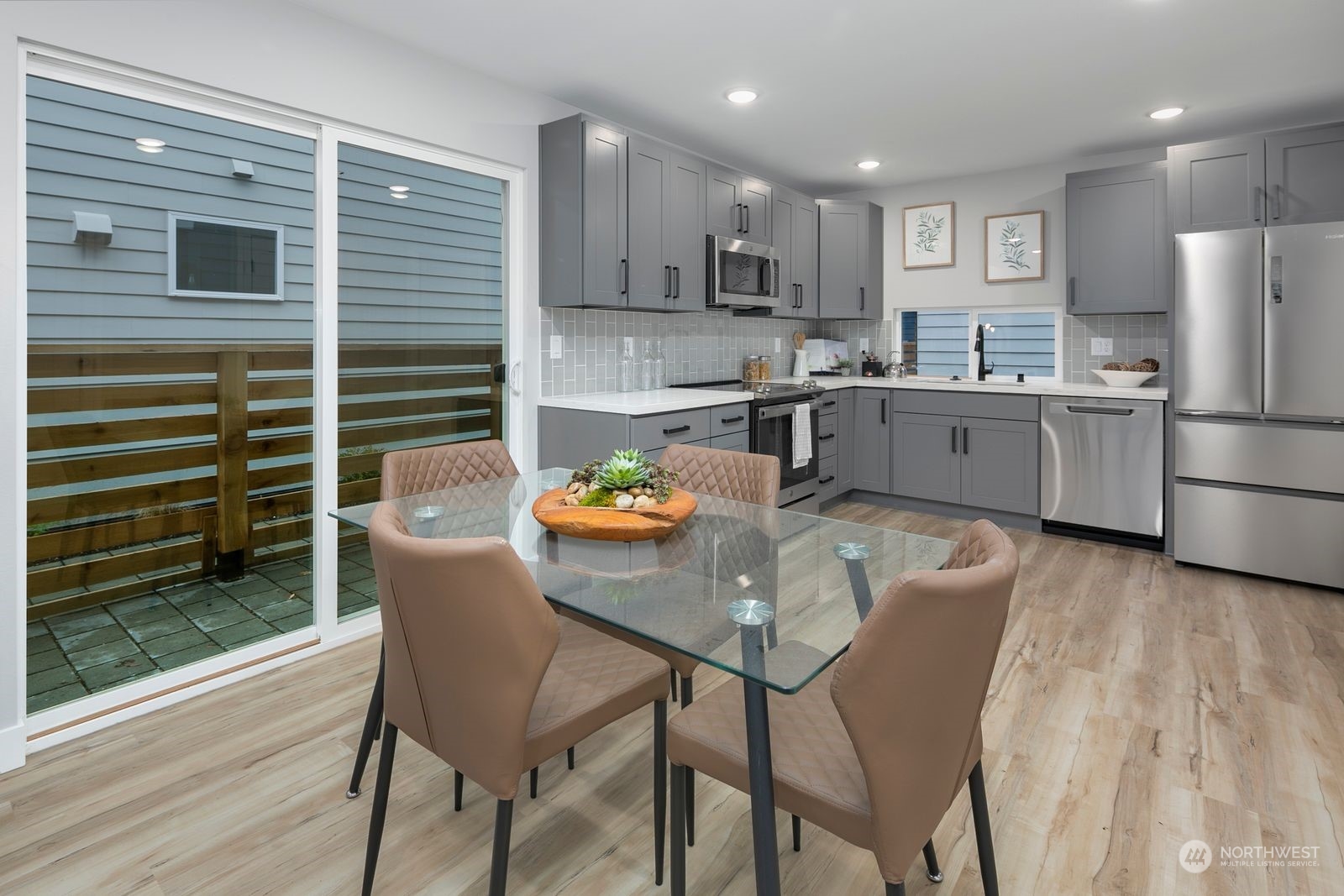 1006 B South Donovan Street Seattle, WA 98108 - Photo 6 of 14 a kitchen with refrigerator a stove and chairs with wooden floor