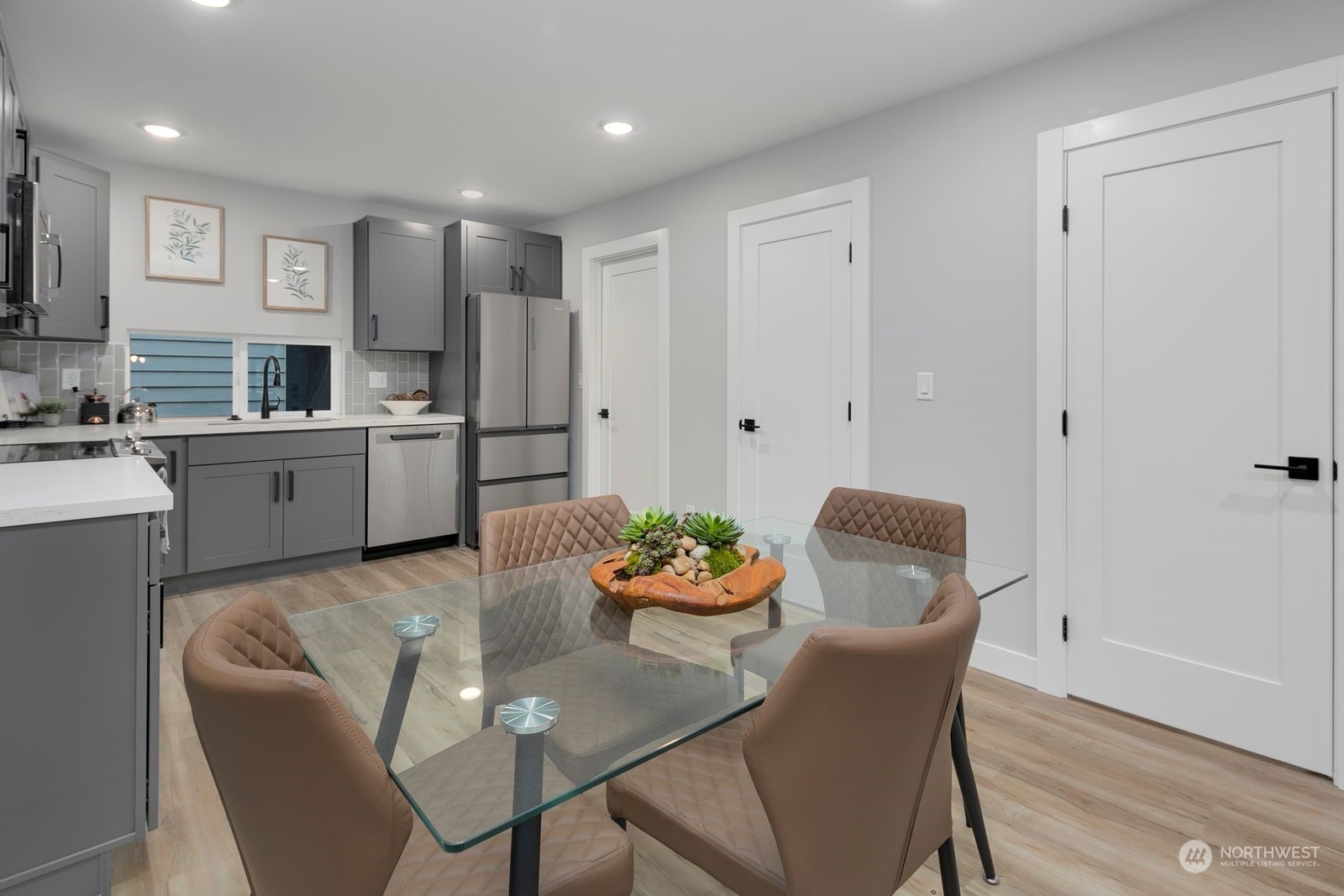 1006 B South Donovan Street Seattle, WA 98108 - Photo 9 of 14 a kitchen with stainless steel appliances granite countertop a dining table chairs and a refrigerator