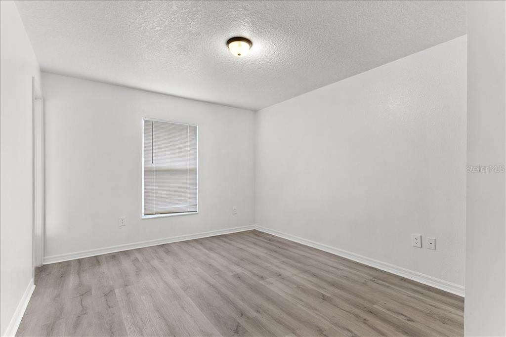 3417 Temple Street, Unit A Tampa, FL 33619 - Photo 15 of 30 an empty room with wooden floor and windows
