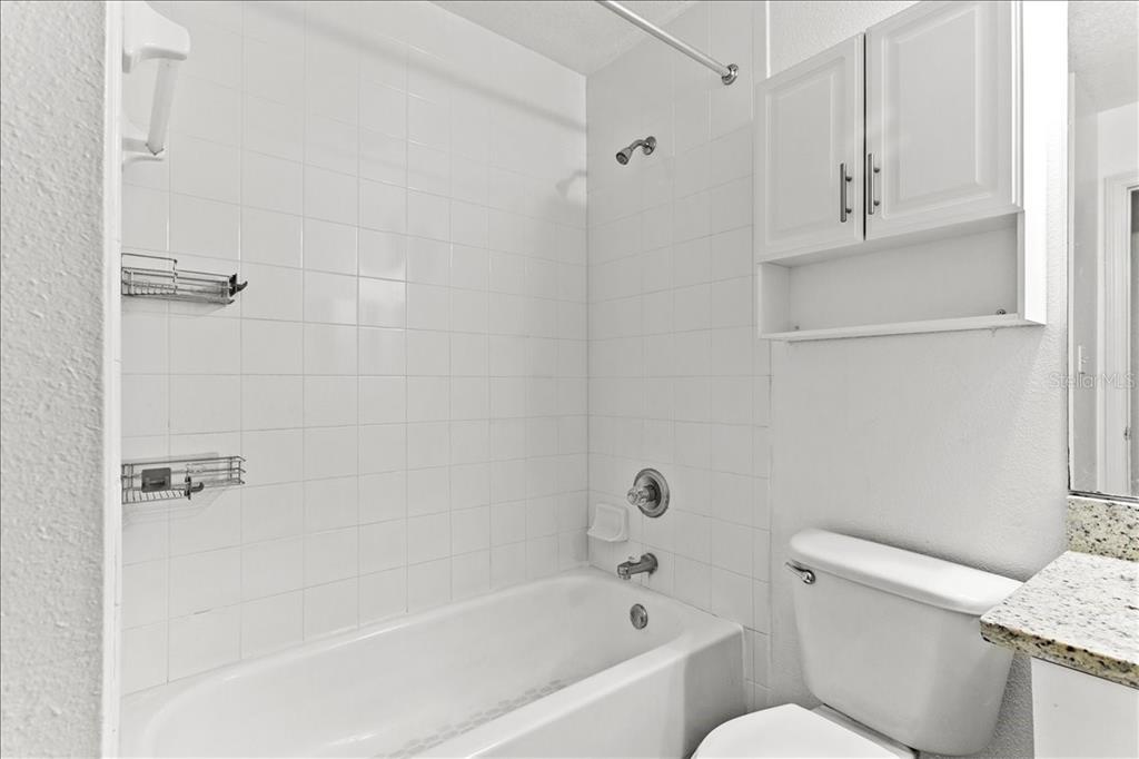 3417 Temple Street, Unit A Tampa, FL 33619 - Photo 17 of 30 a white bath tub sitting next to a white toilet and vanity