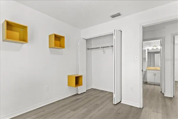 a view of a hallway with wooden floor and a refrigerator