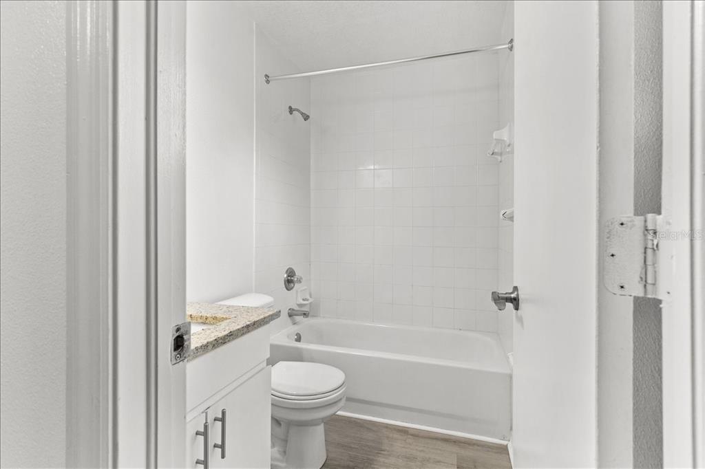 3417 Temple Street, Unit A Tampa, FL 33619 - Photo 23 of 30 a bathroom with a granite countertop sink a toilet and shower