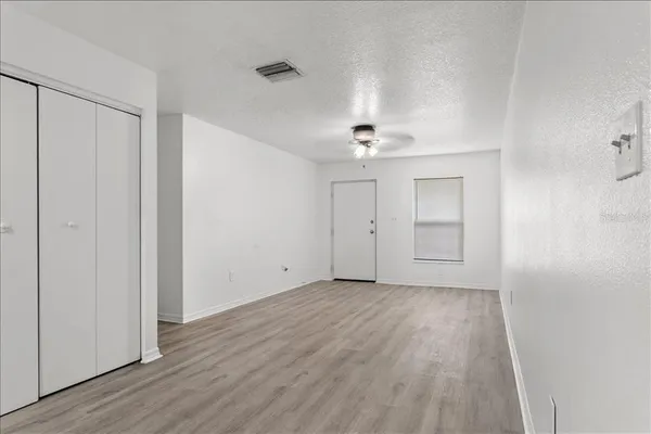 a view of an empty room with wooden floor