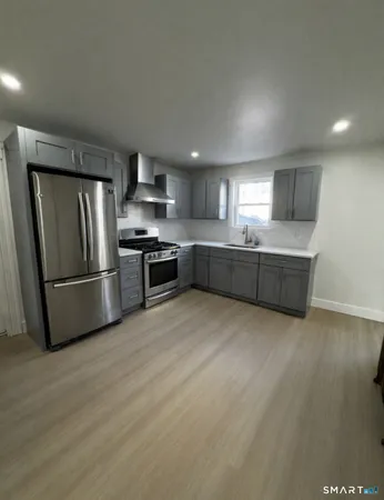 a kitchen with stainless steel appliances granite countertop a refrigerator and a stove top oven