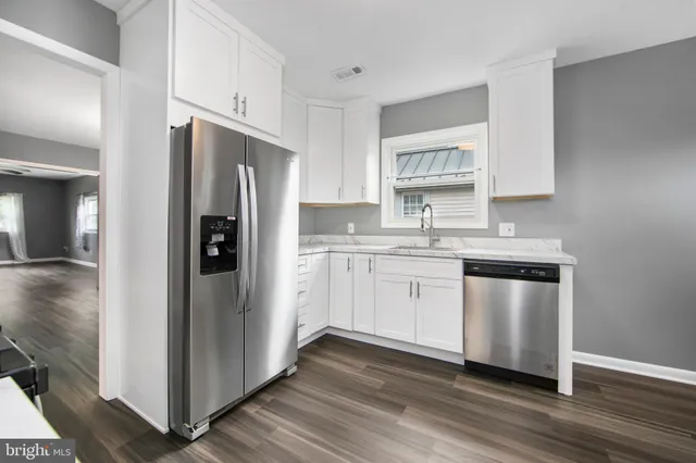 a kitchen with a refrigerator sink and cabinets