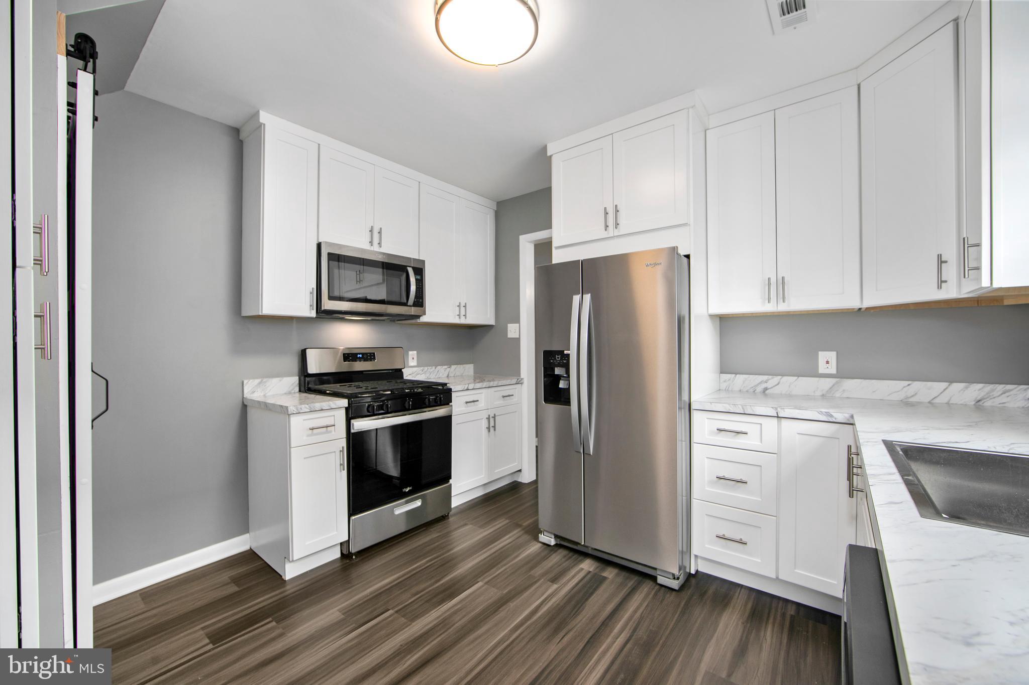 325 Landis Avenue Oaklyn, NJ 08107 - Photo 13 of 46 a kitchen with white cabinets and stainless steel appliances