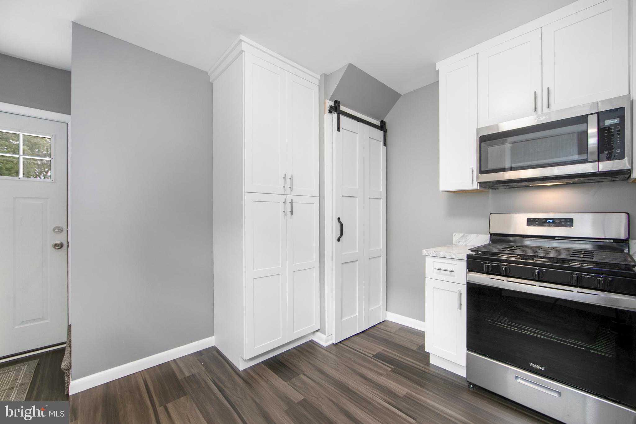 325 Landis Avenue Oaklyn, NJ 08107 - Photo 14 of 46 a kitchen with stainless steel appliances a stove a microwave and a hard wood floors