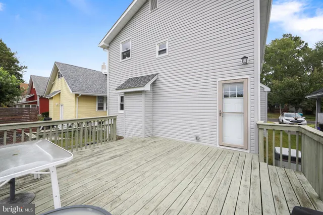 a view of house with deck outdoor seating and covered with wooden floor