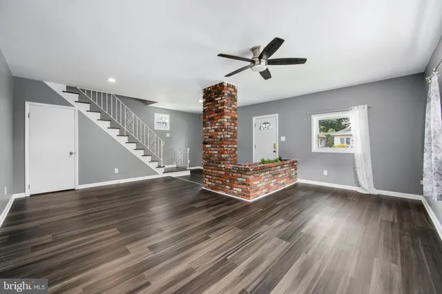 a view of empty room with wooden floor and window