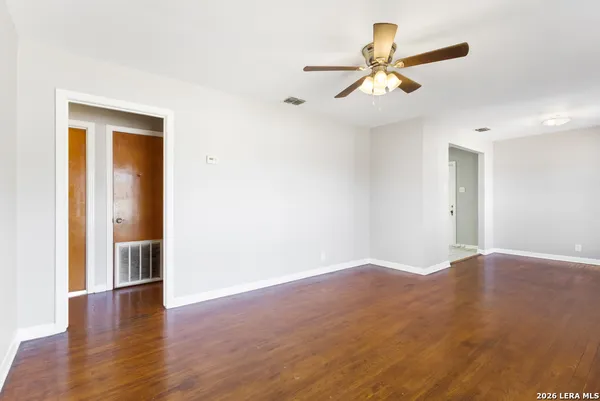 a view of empty room with wooden floor