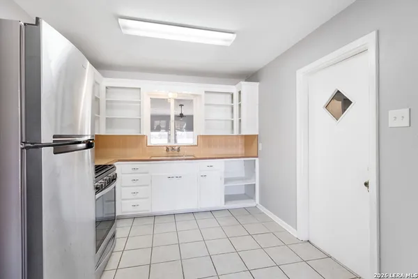 a kitchen with granite countertop white cabinets and refrigerator