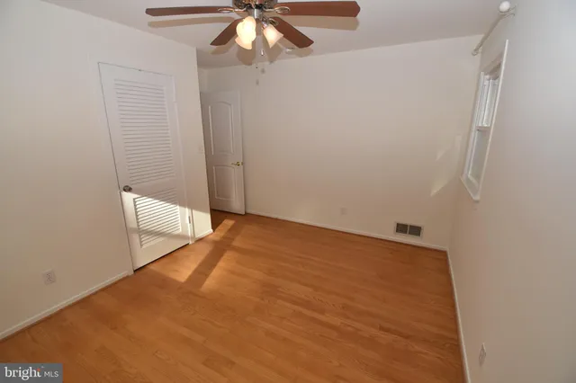 an empty room with a chandelier fan
