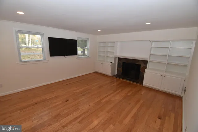 a view of empty room with a fireplace and wooden floor
