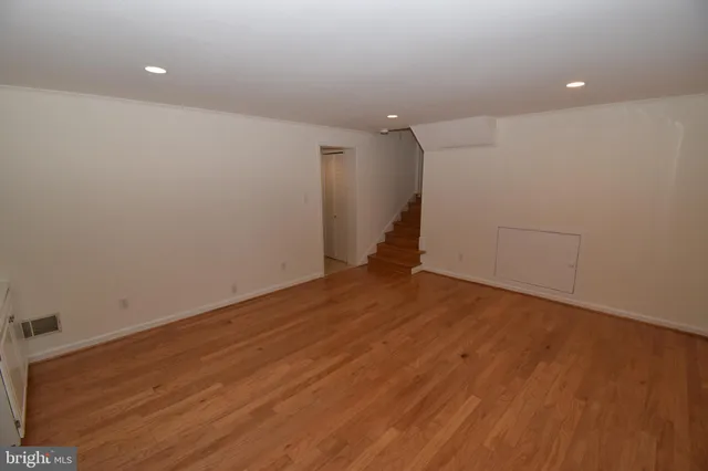a view of empty room with wooden floor