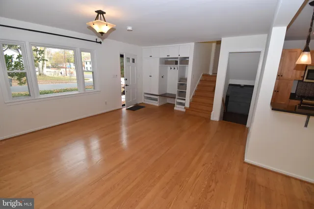 a view of a livingroom with wooden floor and a ceiling fan