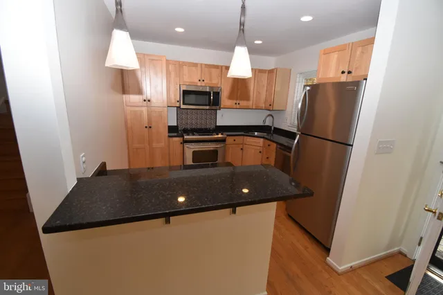 a kitchen with stainless steel appliances granite countertop refrigerator sink stove and a refrigerator