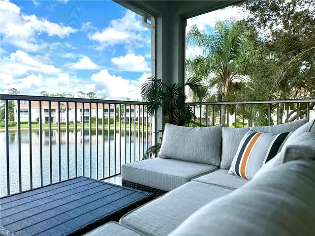 a balcony with wooden floor table and chairs