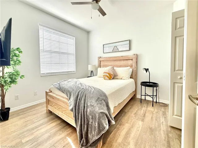 a bedroom with a bed lamp and a potted plant