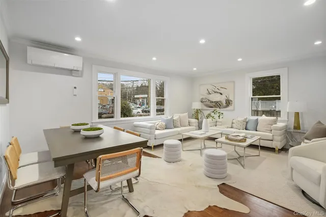 a living room with lots of white furniture and a table