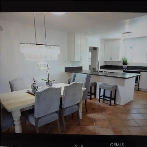 a kitchen with a table chairs and a living room