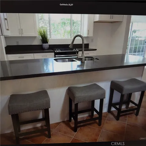 a kitchen with a table chairs and a potted plant