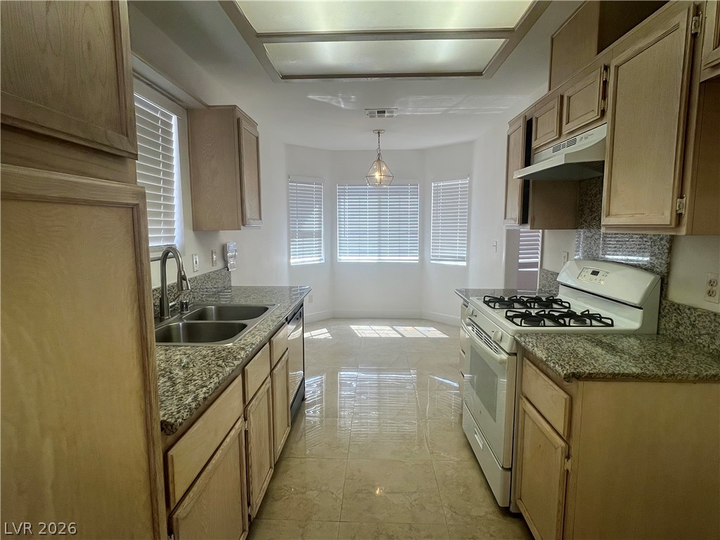 1309 Goldenglow Road Las Vegas, NV 89108 - Photo 6 of 11 A well-lit kitchen with granite countertops and a bright breakfast nook awaits.